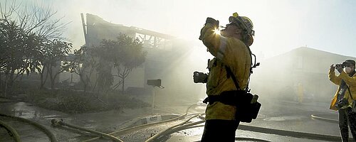 Feuerwehrmann steht vor gelöschtem Brand